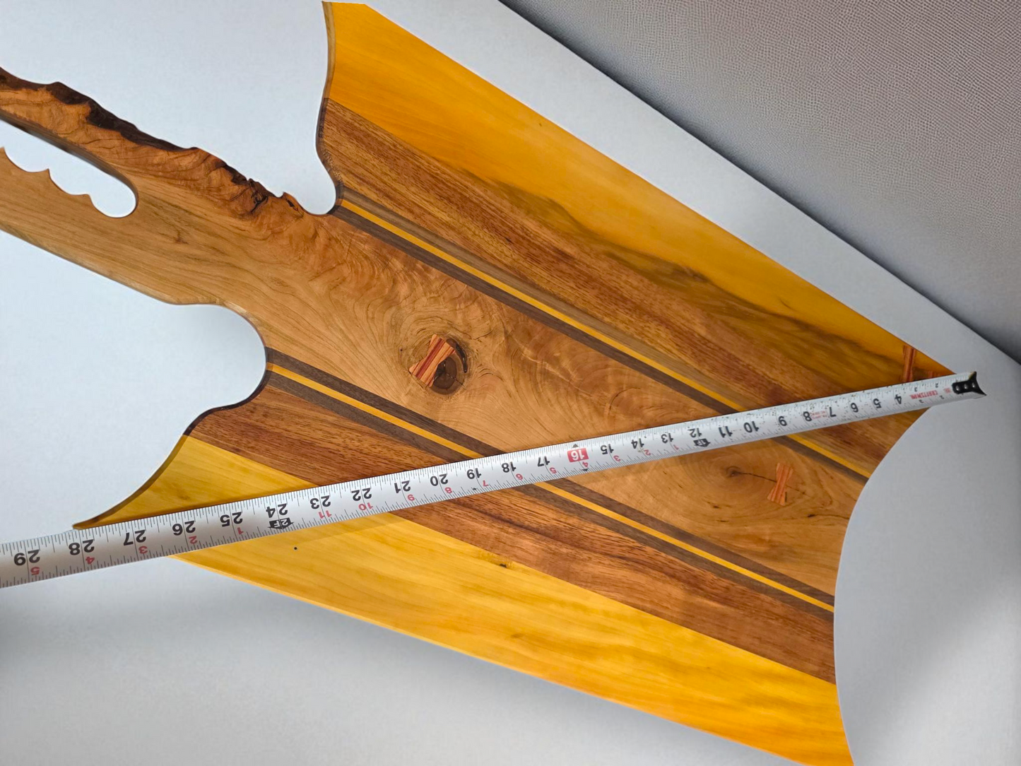 Handmade charcuterie board with a live-edge handle.