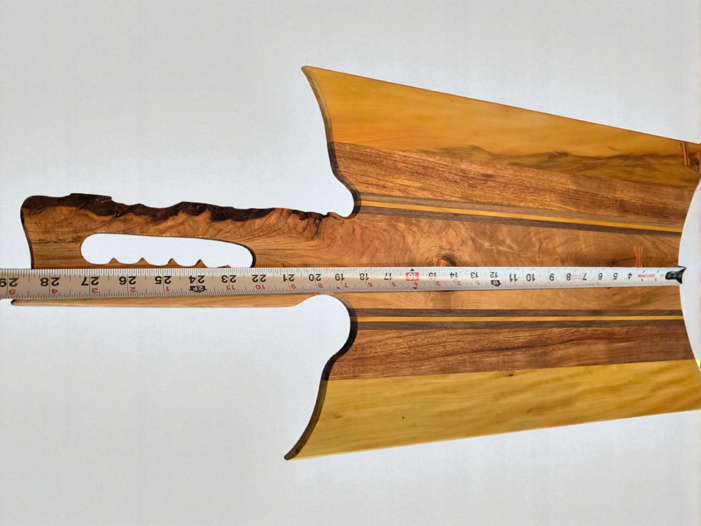 Handmade charcuterie board with a live-edge handle.