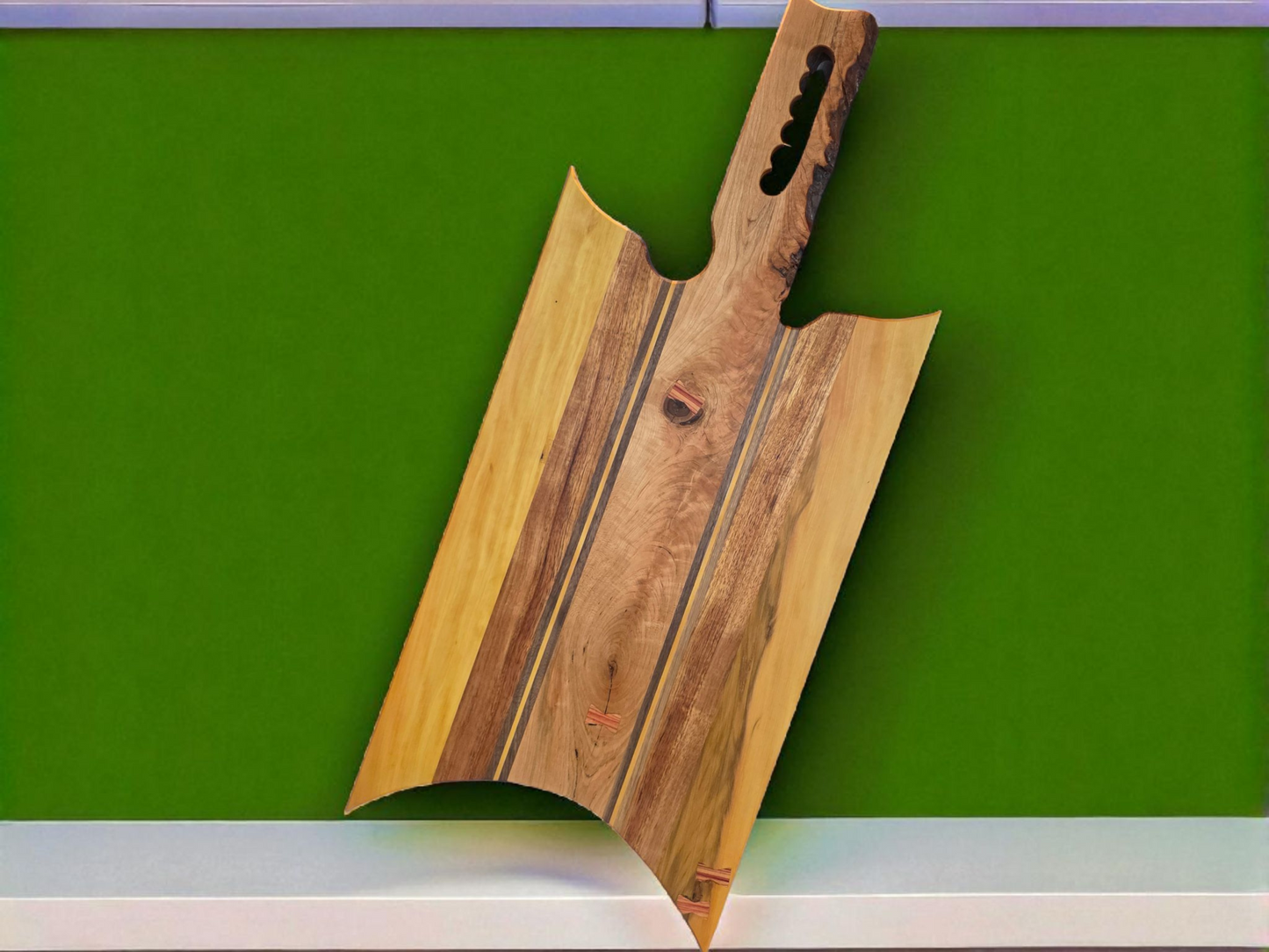 Handmade charcuterie board with a live-edge handle.