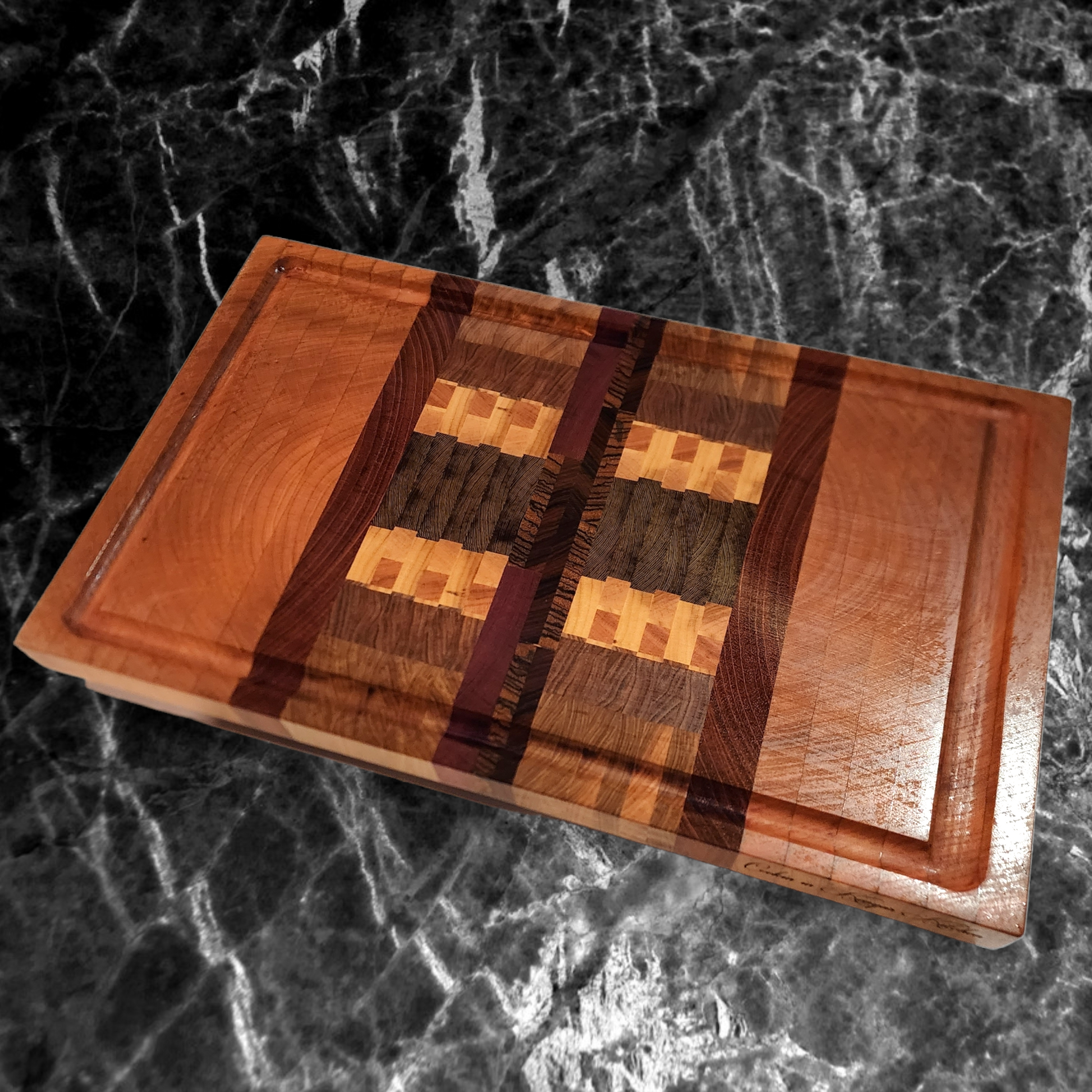 Veteran-owned brand luxury end grain cutting board handcrafted from exotic hardwoods with intricate geometric design