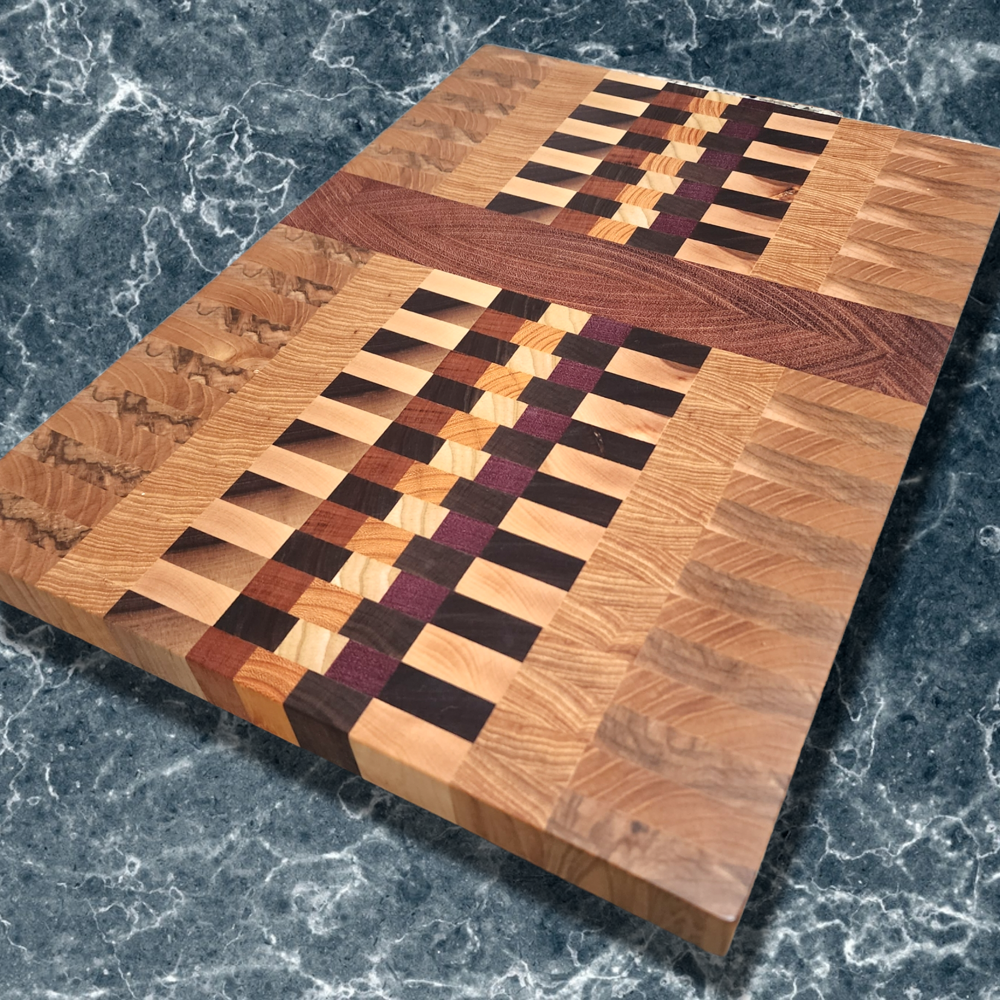 Veteran-owned brand luxury end grain cutting board handcrafted from exotic hardwoods with intricate geometric design